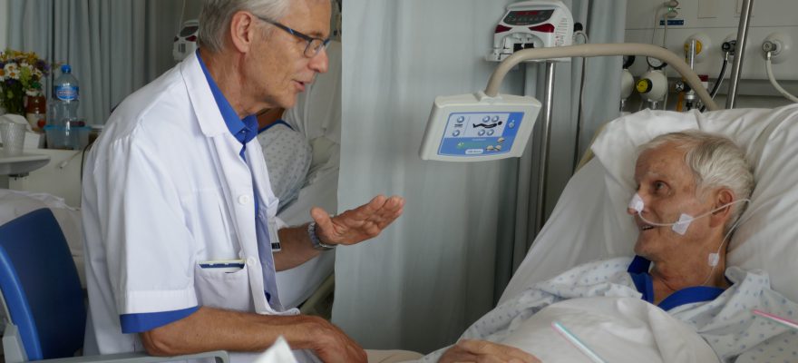 Le pasteur Daniel Pétremand, en blouse blanche, se veut à l'écoute des patients, quelle que soit leur spiritualité.